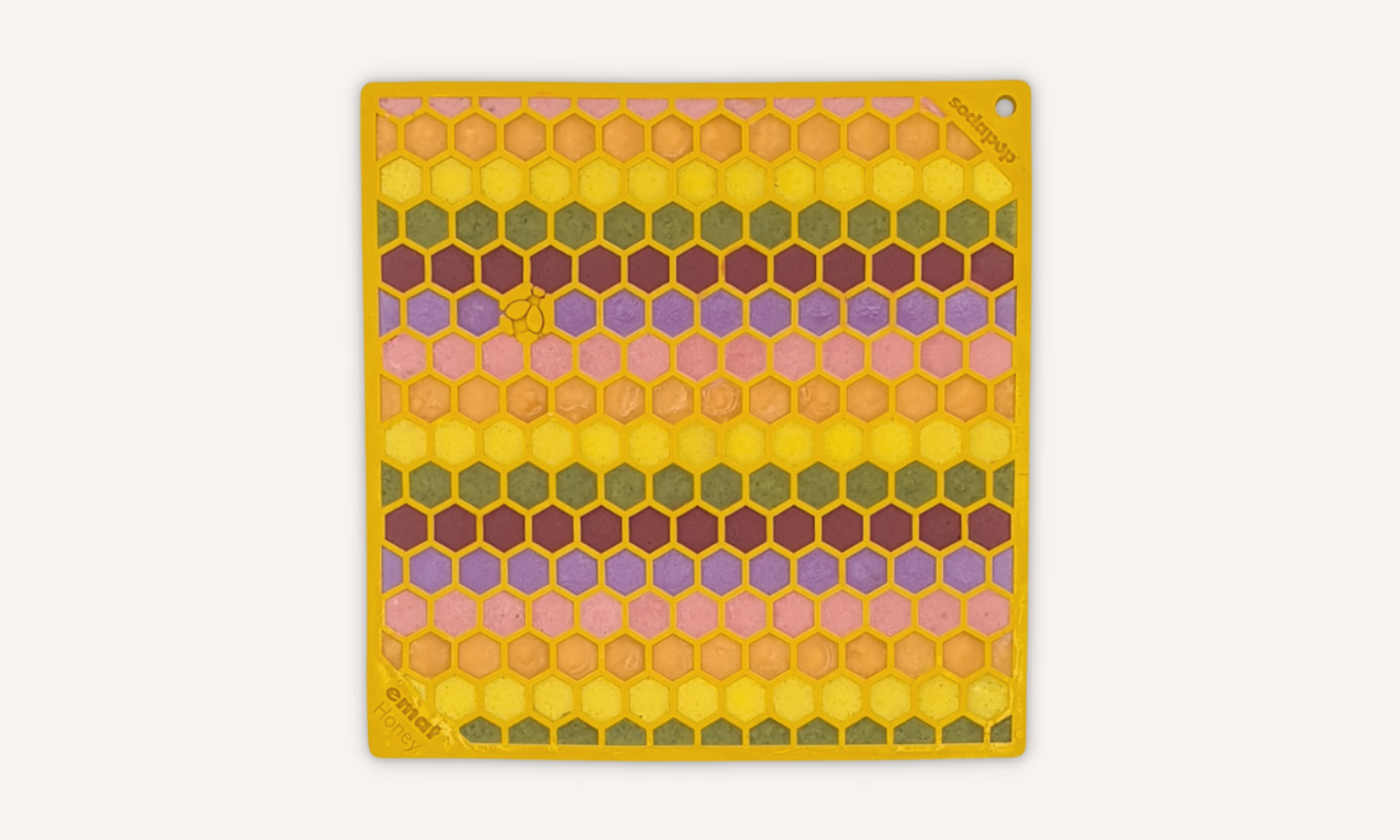 Dog licky mats - yellow dog licking mat with honeycomb shapes filled with a rainbow filling