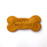 Dog bone-shaped biscuit with 'Happy Woofmas' text on a white background