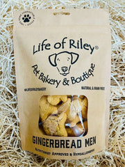 Bag of 'Gingerbread People' dog treats from Life of Riley Pet Bakery & Boutique on a straw background.