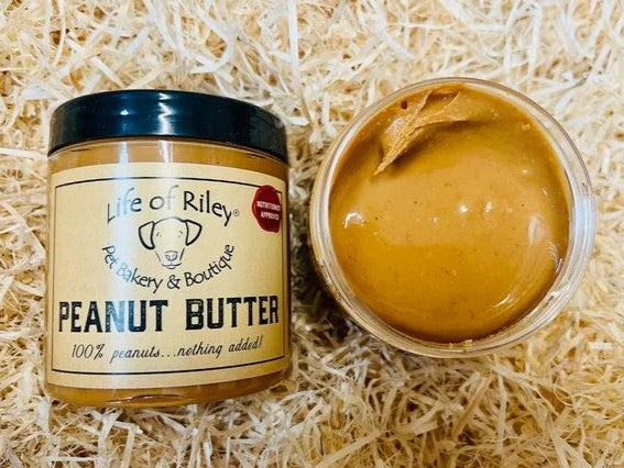 Jar of Life of Riley peanut butter on a straw background