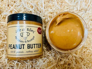 Jar of Life of Riley peanut butter on a straw background