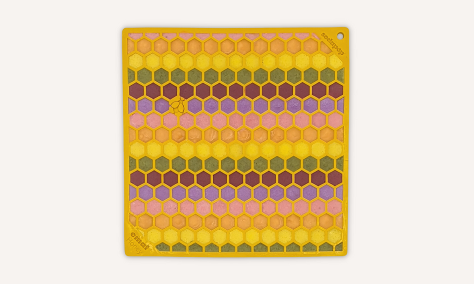 Dog licky mats - yellow dog licking mat with honeycomb shapes filled with a rainbow filling