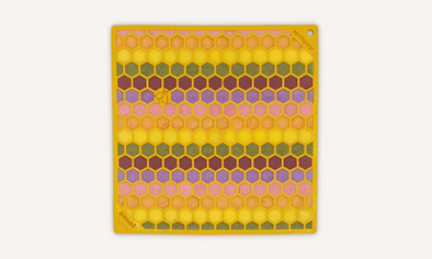 Dog licky mats - yellow dog licking mat with honeycomb shapes filled with a rainbow filling